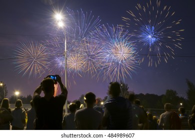 Unrecognizable people watch and shoot fireworks at night in Moscow, Russia, Festival in Brateevo