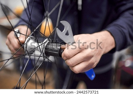 Unrecognizable person assembling a bike wheel axle after disassembling it for cleaning and greasing as part of a bicycle maintenance service. Real people at work.