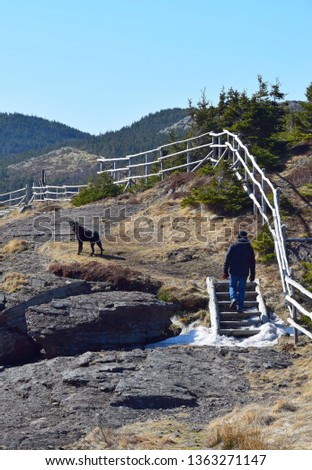 unrecognizable person and black Labrador retriever on a hiking trail, Stiles Cove Path near Flatrock East Coast trail, Newfoundland Canada