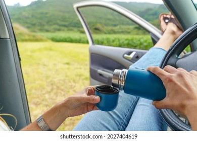 Unrecognizable Person Drinking Fresh Water In The Car. Horizontal View Of Person Refreshing During Heat Wave Traveling.