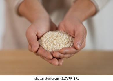 Unrecognizable Person Hands With Handful Of Rice, Closeup Shot. Cropped Of Man Or Woman Holding Grain, Going To Cook Meal For Hungry Family. Crisis And Hunger, Poverty Concept