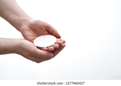 Unrecognizable person holding a communion wafer