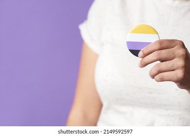 Unrecognizable Person Holding A Non Binary Flag Badge Or Pin. Concepts Of Identity Pride, Gender Diversity, Equality And Non Discrimination.