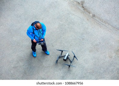 The Unrecognizable Person, Pilot Of The Drone With The Control Panel Prepares For The Next Flight On Quadcopter UAV`s Drone For Commercial Aerial Photography. 