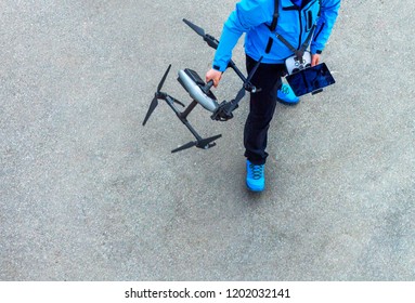 The Unrecognizable Person, Pilot Of The Drone With The Control Panel Prepares For The Next Flight On Quadcopter UAV`s Drone For Commercial Aerial Photography.