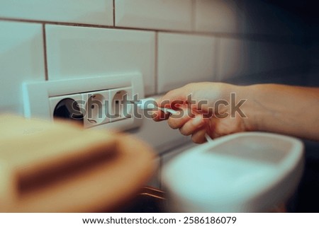 
Unrecognizable person Puts a plug in a Kitchen Socket 
Woman using electric appliance afterwards unplugging it 