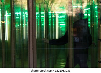 Unrecognizable Person Seeking The Way Out In A House Of Mirrors, A Glass Maze On An Amusement Funfair, Copy Space, Selected Focus