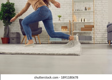 Unrecognizable person trips over rug at home. Clumsy faceless woman in uncomfortable shoes stumbles on rug in living-room and falls down on floor. Concept of getting injured in domestic accidents