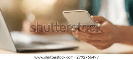 Unrecognizable Person Using Smartphone While Working On Laptop At Office, Business Concept