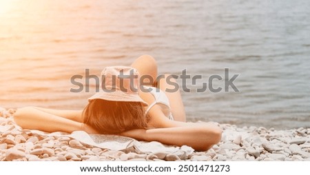 Unrecognizable positive woman in white bikini sunbathing or tanning on seaside beach during summer. Slow motion of happy tourist enjoying sun tan lying on beach chair lounge at luxury resort