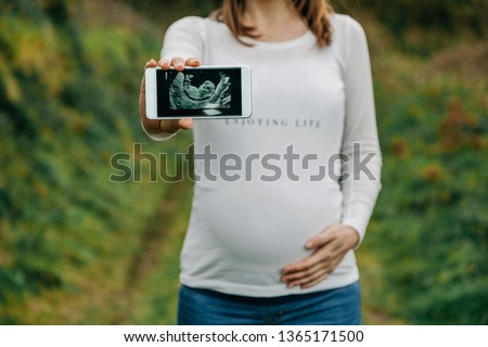 Similar – Unrecognizable pregnant woman showing ultrasound of her baby on the mobile