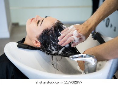 Unrecognizable professional hairdresser washing hair to her client. Beautiful hairdresser washing hair to her client lady in hairdressing saloon. Client sitting with her eyes closed. - Shutterstock ID 1177082977
