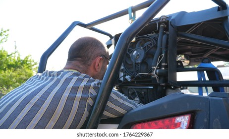 Unrecognizable Repairman Or Mechanic Repairing Vehicle. Male Repairer Fixing Automobile. Auto Master Doing His Work Outdoor At Sunny Day. Man Engaged In Servicing Auto. Car Service. Slow Mo Dolly Shot