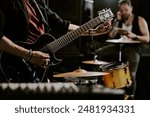 Unrecognizable rock musician playing in band preparing for performance tuning electric guitar, copy space