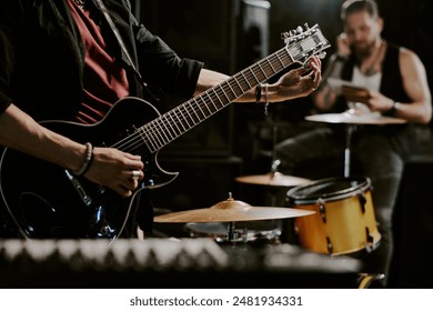 Unrecognizable rock musician playing in band preparing for performance tuning electric guitar, copy space - Powered by Shutterstock