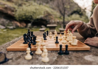 Unrecognizable Senior Couple Playing A Game Of Chess In A Park. Anonymous Elderly Couple Spending Quality Time Together After Retirement.