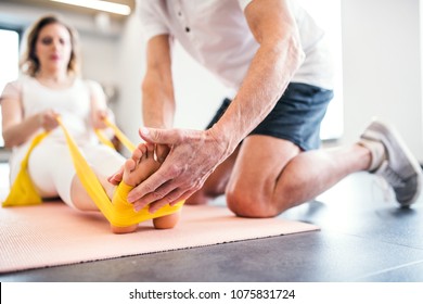Unrecognizable senior physiotherapist working with a female patient. - Powered by Shutterstock