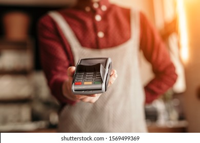 Unrecognizable Showing Payment Terminal To Camera And Offering To Pay For Order While Working In Cafe