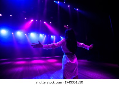 Unrecognizable Singer Standing On Stage At Microphone, Back View, Neon Lights