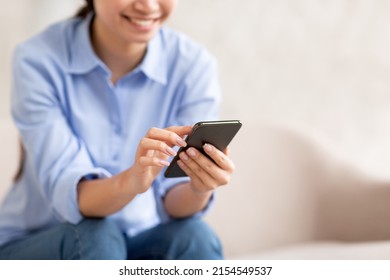 Unrecognizable Smiling Lady In Casual Outfit Sitting On Sofa At Home, Using Brand New Cell Phone, Chatting With Guys Via Dating Mobile App, Checking Newest Shopping Application, Copy Space, Panorama