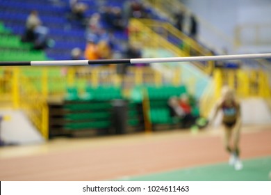 Unrecognizable sportswoman before high jump attempt over bar on track and field competition - Powered by Shutterstock