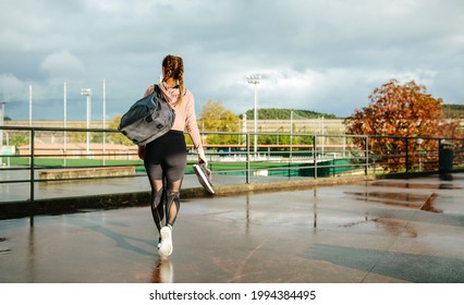 Unrecognizable sportswoman with gym bag and sports shoes walking to go to training - Powered by Shutterstock