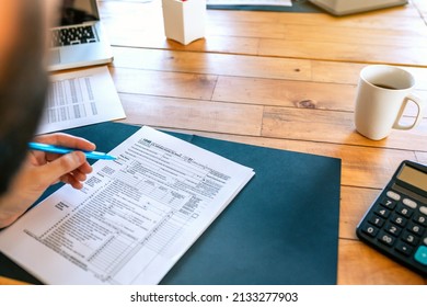 Unrecognizable taxpayer filling in individual income tax return - Shutterstock ID 2133277903