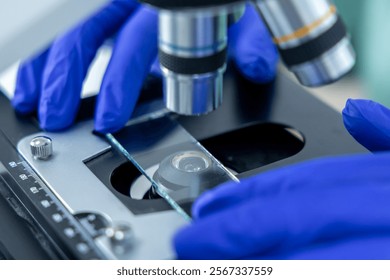 Unrecognizable technician looking at samples under microscope for test in pharmaceutical research
