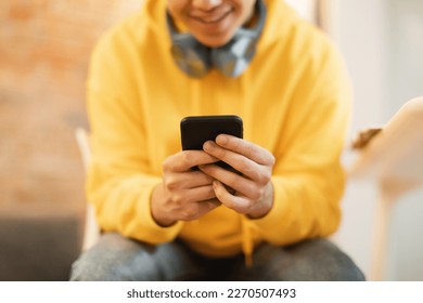 Unrecognizable Teen Boy Using Phone Playing Mobile Games Online And Texting In Social Media Application Sitting Indoors. Teenagers And Gadgets Lifestyle. Cropped, Selective Focus On Smartphone - Powered by Shutterstock