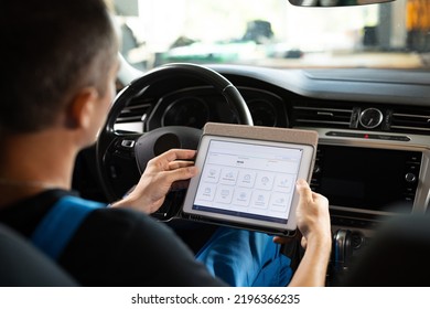 Unrecognizable Vehicle Service Manager Worker Work In Mechanics Garage, Check And Maintenance To Repair The Engine Car In Workshop. Automotive Mechanic Running Diagnostics Software On Tablet.