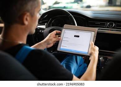 Unrecognizable Vehicle Service Manager Worker Work In Mechanics Garage, Check And Maintenance To Repair The Engine Car In Workshop. Automotive Mechanic Running Diagnostics Software On Tablet.