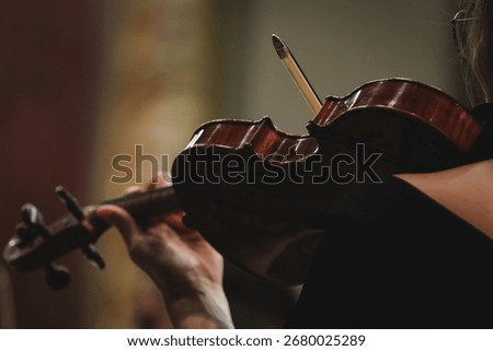 Unrecognizable violin player performing in orchestra ensemble 