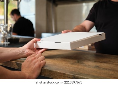 Unrecognizable Waiter Giving Pizza Box To A Faceless Customer. Pizzeria Delivery.