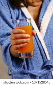 An Unrecognizable Woman In A Bathrobe Is Holding A Glass Of Blood Orange Soda