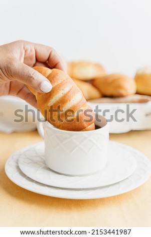 Unrecognizable woman dipping homemade Guatemalan sweet bread in a cup of coffee