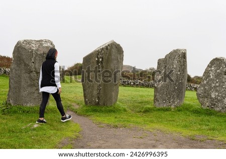 Unrecognizable woman enjoying and attentively observing the architectural complex of the Neolithic period in County Cork composed of large megaliths in a circle