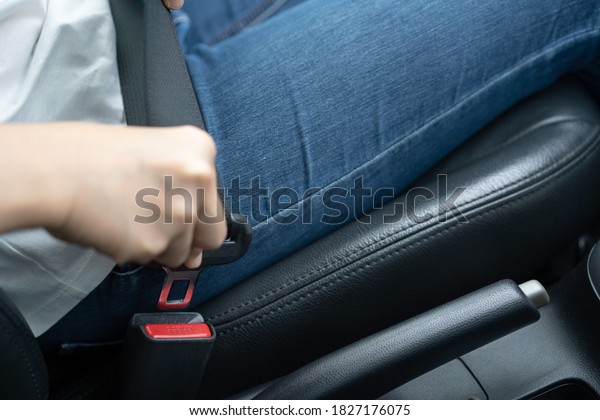 Unrecognizable\
woman fastening a seat belt before driving a car, fasten seat belt\
is a driver\'s responsibility for safety driving. Safety belt able\
to prevent the dead from vehicle\
accident.