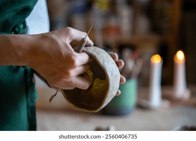 Unrecognizable woman hands with knife, shaping bowl from white clay in pottery workshop, crafting handmade ceramics. Honing skills in pottery, focused craftsmanship, functional art with manual labor - Powered by Shutterstock