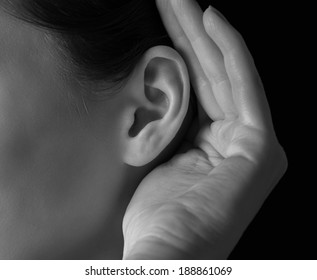 Unrecognizable woman holds her hand near ear and listens, close-up - Powered by Shutterstock