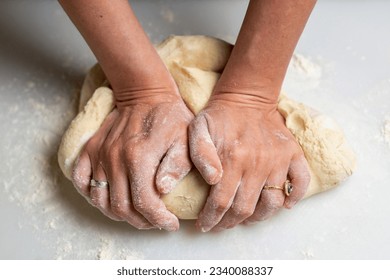 Unrecognizable woman kneading dough. Dough for dumplings, dumplings, pies.