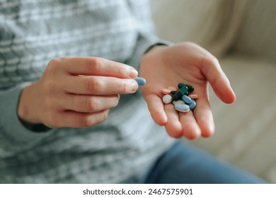 Unrecognizable woman takes medication, lot of pills to drink, bunch of pills in her hand. Full palm of vitamins and minerals to drink. Health concept. Top view, close up. At home. - Powered by Shutterstock