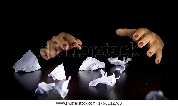 Unrecognizable woman throwing crumpled paper,\
having nervous breakdown at work, stress management. Womans hands\
tearing papers.