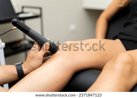 An unrecognizable woman visits a physiotherapy clinic to undergo shockwave therapy to relieve pain in her knees. Concept of shockwave therapy.SWT therapy.