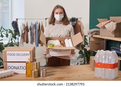 Unrecognizable Woman Wearing Mask And Latex Gloves Holding Cardboard Box With Food Supplies For Donation