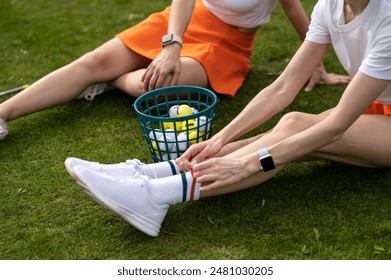 Unrecognizable women golfers sitting by the golf cart on the green lawn - Powered by Shutterstock