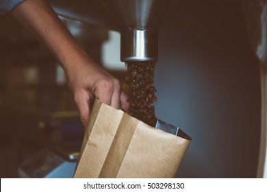 Unrecognizable Worker Holding Bag And Filling It With Coffee Beans