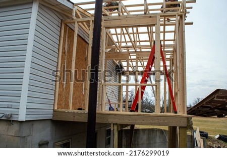 Unrecognizable workers are intent on doing a good construction job with the addition of a new room on this home.
