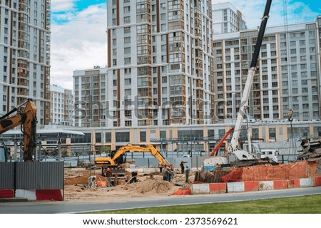 Unrecognizable workers and technic work at modern construction site of appartment recidential building in city. 