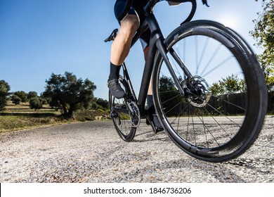 unrecognizable young adult man training on his road bike on a mountain road
