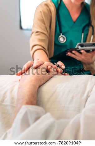 Female doctor comforting older patient